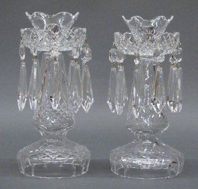 Pr Waterford candle sticks: A pair of 20th century Waterford Crystal candle sticks. Flared tops with bobeches and hanging prisms on baluster bases with diamond cutting. Acid etched marks. Slight wear, lacking candle cups. Each 9