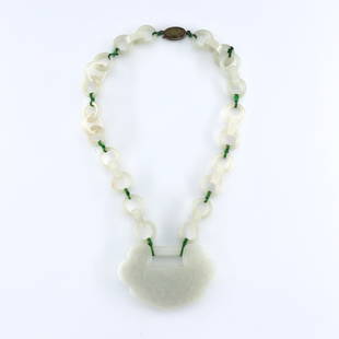 Chinese White Jade Necklace: A 19th century Chinese White Jade pendant necklace. Carved Lock form pendant with Bird and Lotus design suspended on a triple-ring Jade chain with Green silk thread. Minor surface wear. Pendant is 3 1