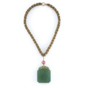 Chinese Green Jade Necklace: A turn of the century Chinese Green Jade pendant necklace. Pierced Jade pendant with carved characters suspended from a coiled Gold Filled Byzantine style chain with Pink Tourmaline stone and seed Pea