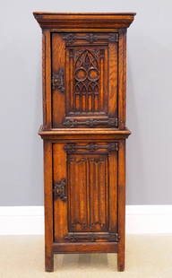 Gothic Revival Side Cupboard: A turn of the century Gothic Revival Period carved Oak side cupboard. Molded top over one central door with carved tracery, flanked by rope twist columns, over a lower door with linen fold carved pane