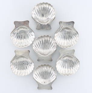 7 Mexican Sterling Salts: A set of seven 20th century Mexican Sterling Silver shell form salts. Each impressed "Sterling / Mexico". 5.64 troy ozs total. One with repaired foot, minor surface wear. 2 3/4" long. ESTIMATE $100-20