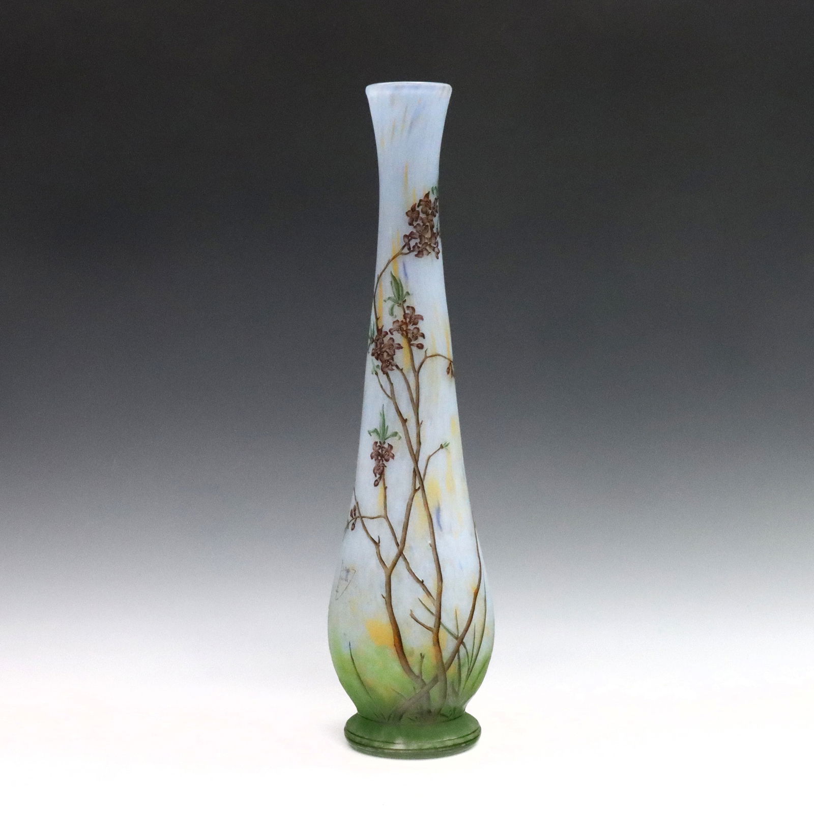Daum Cameo Glass Vase: A turn of the century Daum Nancy Cameo Glass vase. Tall slender form with multi-color floral decoration on a Blue/Green landscape ground. Signed "Daum Nancy" with Cross of Lorraine at side. Minor wear