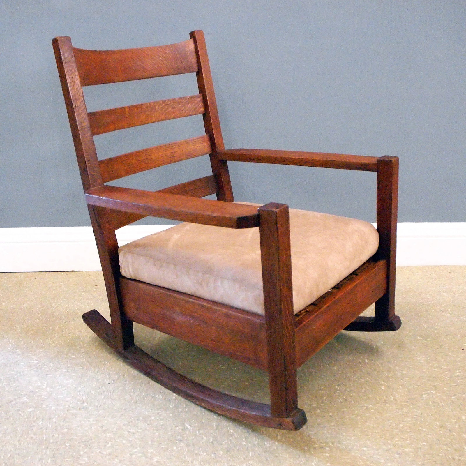 Arts & Crafts Rocking Chair: A turn of the century American Arts & Crafts Period rocking chair. Quartersawn Oak construction with four horizontal splats over a lift-out upholstered seat cushion and stretcher base. Unmarked. Older