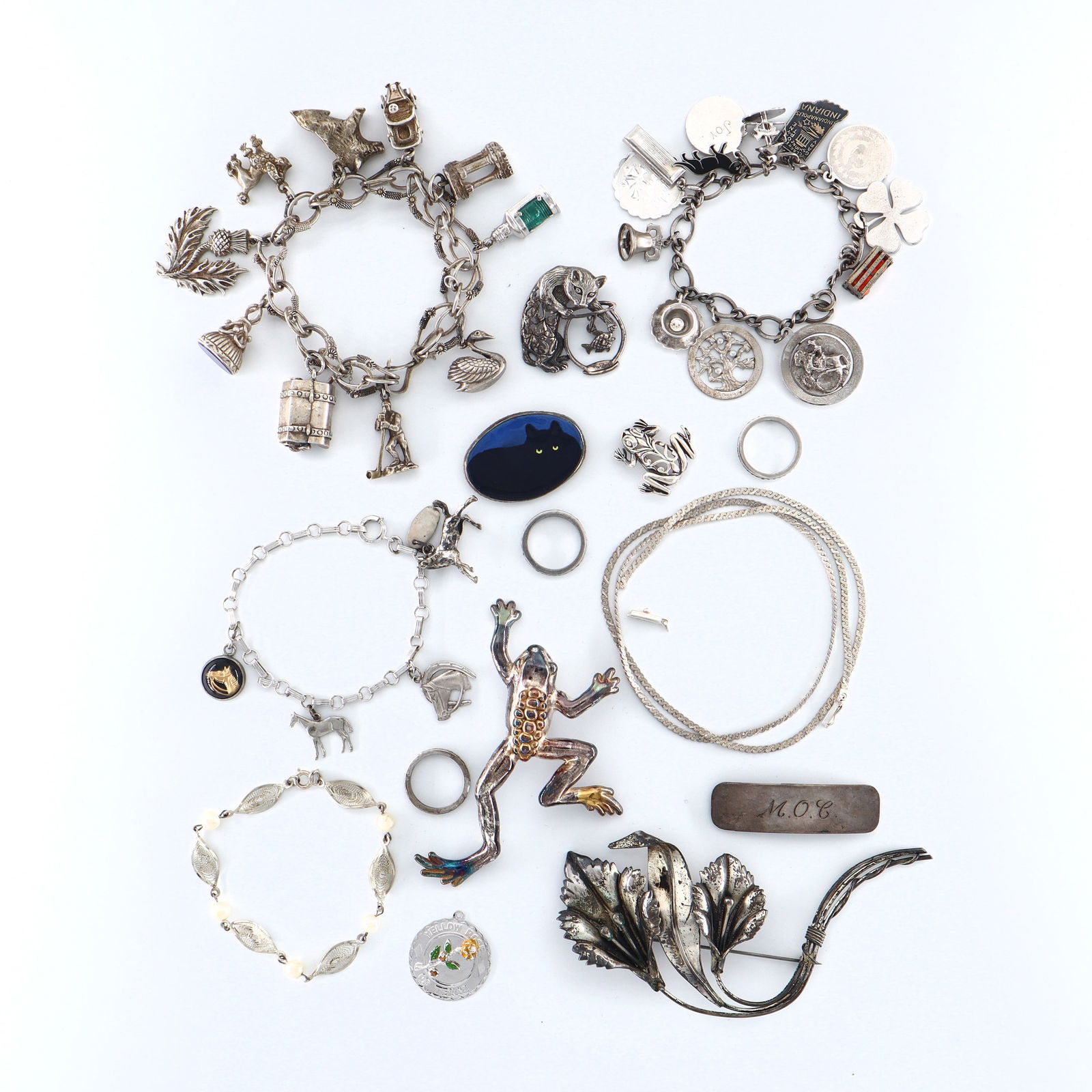 12 pc Silver Jewelry: A collection of Silver jewelry. Includes three charm bracelets, five brooches, a filigree pearl bracelet, three stacking rings, an Italian chain necklace and a clip. Impressed "Sterling", "925" and "8