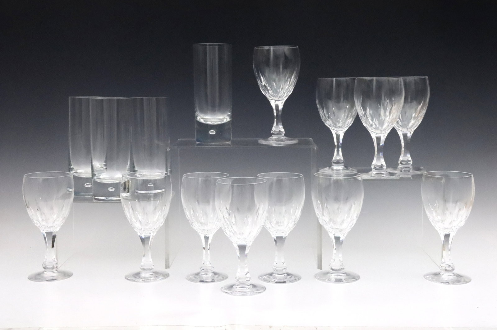 15 Kosta Boda Crystal Glasses: Fifteen mid to late 20th century Kosta Boda Crystal glasses. Includes eleven "Fontain Clear" pattern wine glasses, and four "Pippi Clear" pattern tumblers. Wine glasses purchased at Tiffany's in Swede