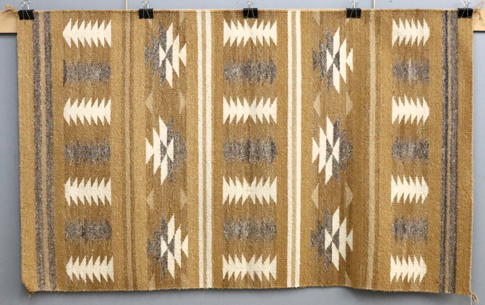 Navajo Wide Ruins Rug: A 5.4' x 3.3' mid 20th century Navajo Wide Ruins rug. Grey and White banded geometric design on a Golden Tan field. Retains label from "Don Watson's Trading Post" Colorado. Minor wear and discoloratio