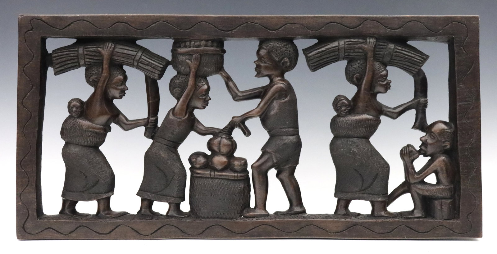 Mozambican Carved Panel: A Mozambican carved hardwood panel depicting figures in daily life. Some wear. 23 1/4 x 11 1/4" high overall. ESTIMATE $200-400 NOTE: From the collection of Fred Brown, Brighton, Michigan. Purchased i