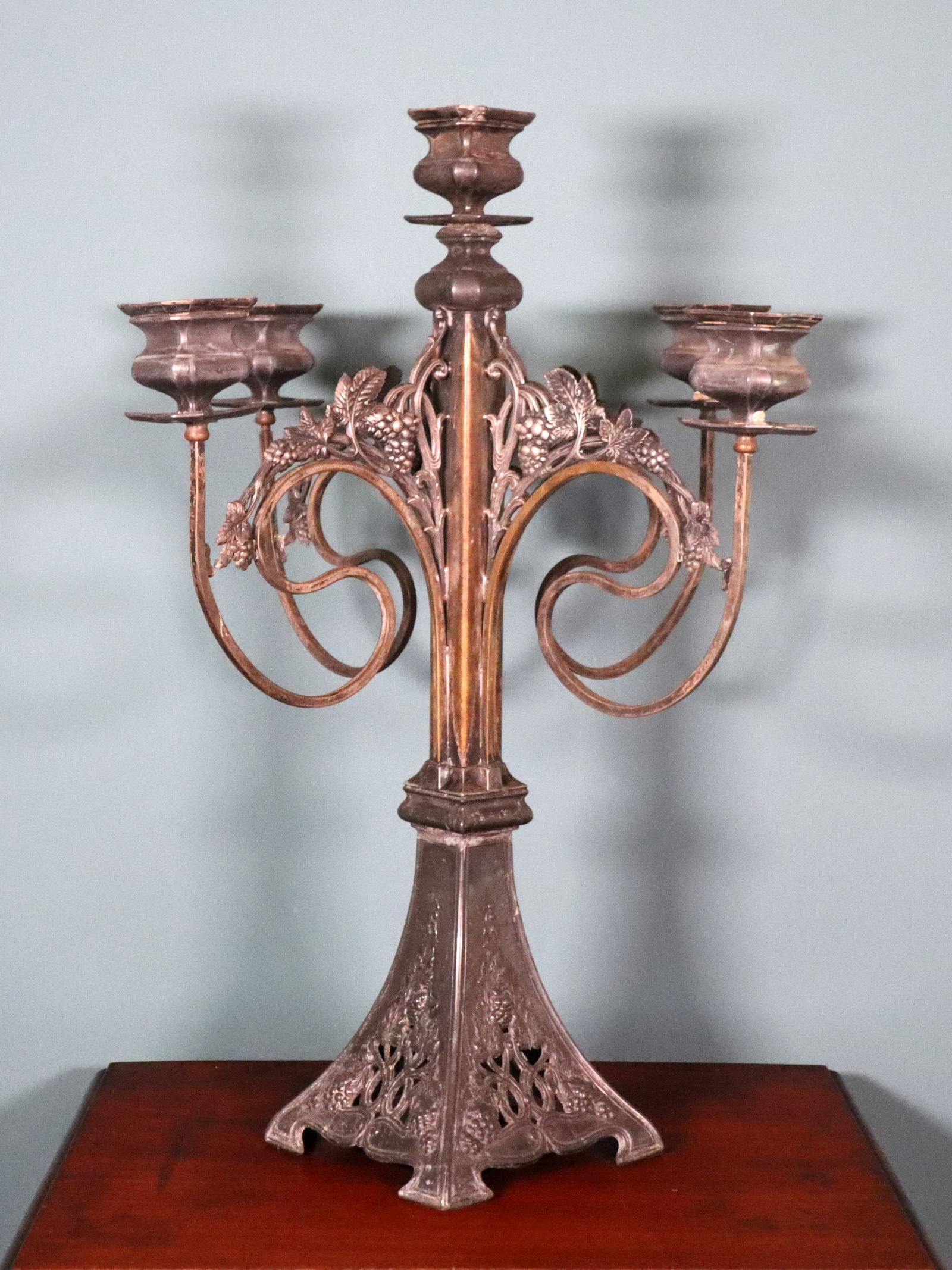 Art Nouveau Pewter Candelabrum: A late 19th century Art Nouveau Pewter candelabrum. Five light design with scrolled Grape Vine arms and pierced foot. Some oxidation, wear to original Gilded finish at stem, deep scratches to bobeches