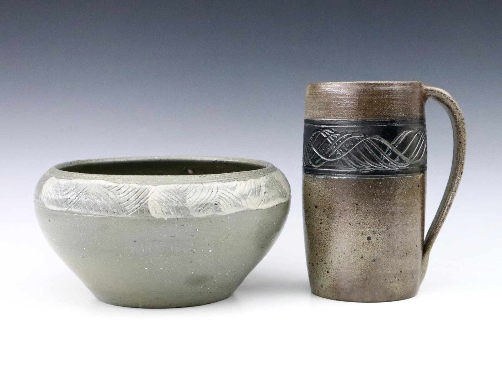 Jugtown Pottery Bowl & Mug: A 20th century Jugtown Pottery bowl and mug. Tapered and cylindrical forms with incised decoration and Grey and Brown glaze. Impressed "Jugtown Ware" marks. Minor wear. Bowl is 8 1/2" diameter x 4 1/2