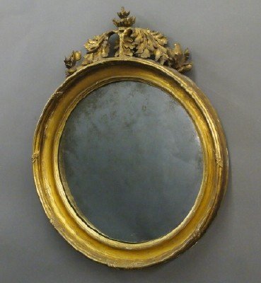 Regency wall mirror: A 19th century English Regency Period "Bull's Eye" wall mirror. Molded circular frame with original convex mirror and carved foliate crest. Old finish with wear and minor damage. 21" wide x 26 1/2" hi
