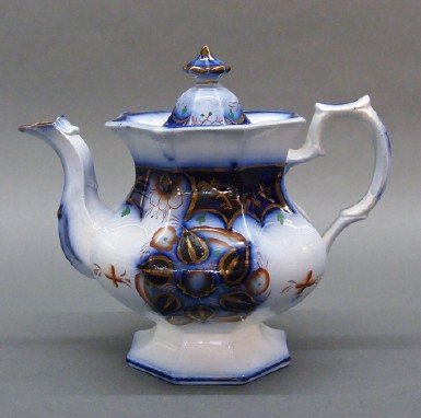 Ironstone teapot: A 19th century English Ironstone teapot. Octagonal form with Blue transfer design and Gaudy Welsh decoration. Unmarked, minor edge flakes under cover. 8 1/2" high. ESTIMATE $100-200