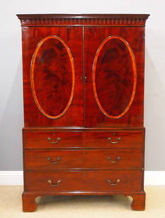 George III Linen Press: A late 18th century English George III Period linen press. Mahogany construction with oval figured Mahogany door panels and Kingwood banding, features a lift off molded cornice above a two door