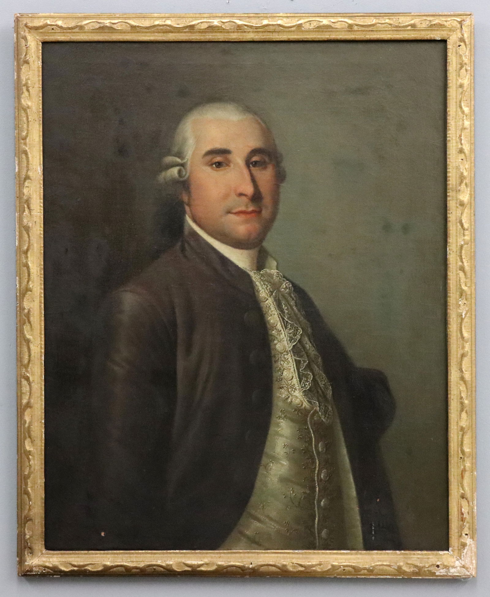 Portrait of a Gentleman: An 18th century oil on canvas portrait of a gentleman. Depicted half length in dress attire and silk vest. Unsigned. Canvas lined with previous repairs, minor craquelure and surface grunge, a few flak