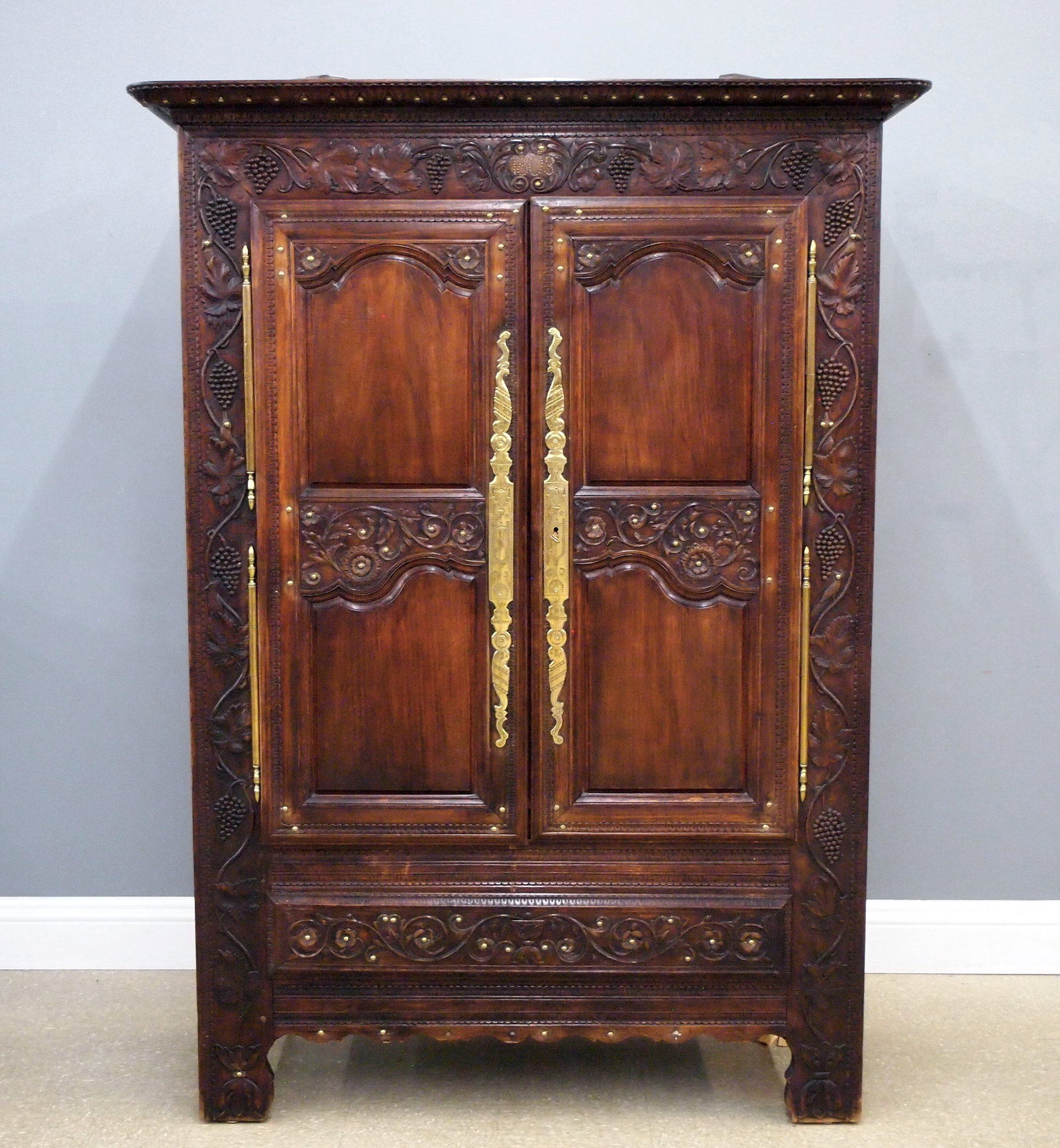 Northern French Armoire: An early 19th century French armoire from Brittany. Extensive hand-carved "vintage" decoration and Brass tacks, dated "1803" at the upper frieze. Walnut construction features a lift off-carved crown a