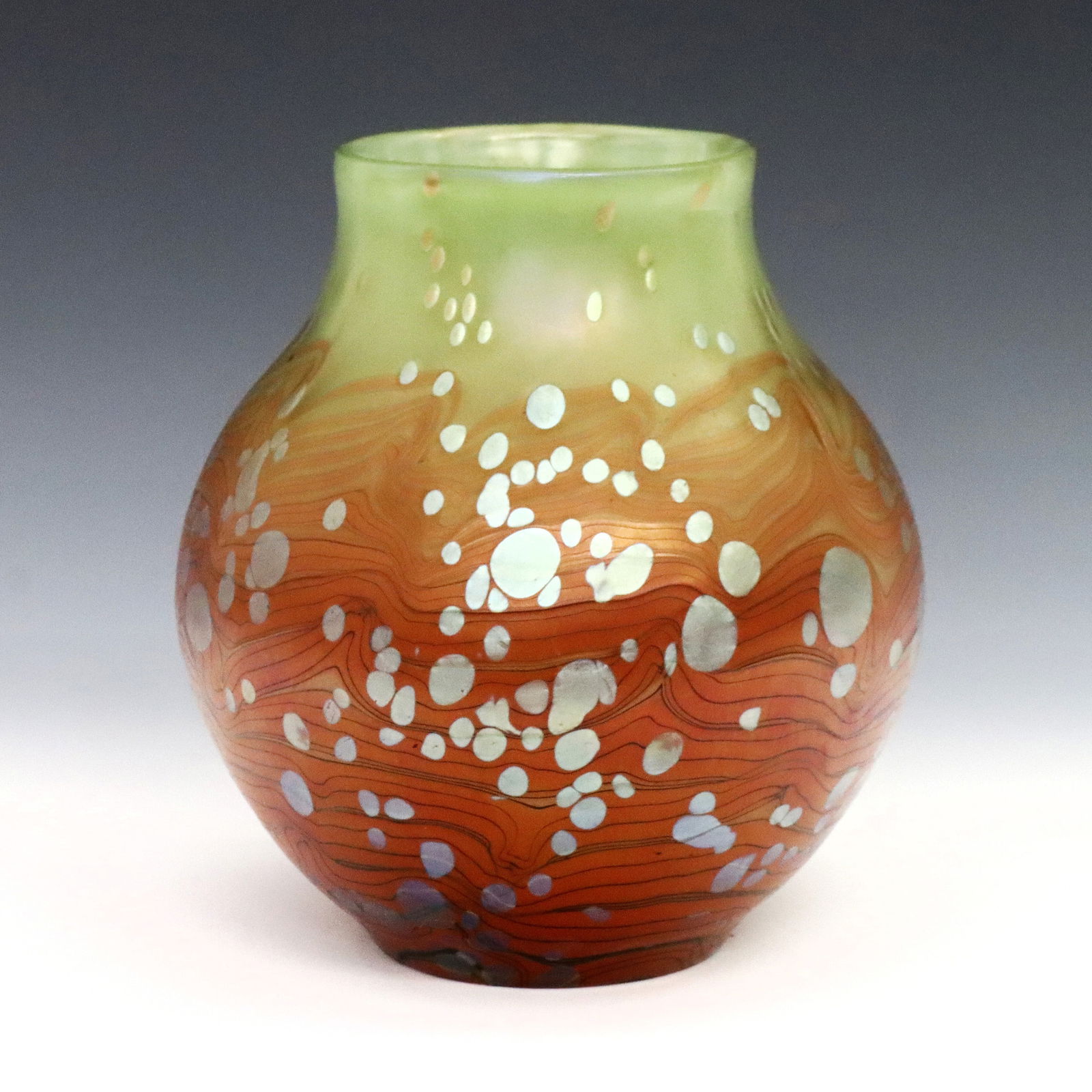 Loetz Cytisus Art Glass Vase: A turn of the century Loetz Cytisus Art Glass vase. Bulbous form in mottled May Green to Orange glass with pulled linear decoration. Minor surface wear. 6 1/2" high. ESTIMATE $800-1,200
