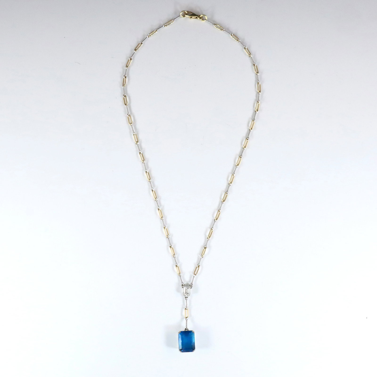 18k Gold, Tourmaline & Diamond Necklace: An Italian 18k Gold drop pendant necklace with Blue Tourmaline and Diamond. Features an emerald cut prong set Tourmaline approx. 11 x 14 mm, below a rectangular cut prong set Diamond approx. 4.5 x 6 m