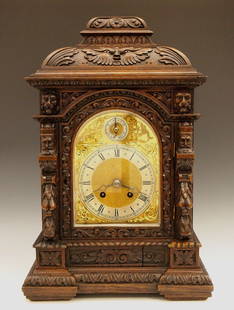 German Carved Oak Bracket Clock: A turn of the century German Carved Oak Bracket clock. 8-day time and strike movement with quarter hour "Bim-Bam" striking on two coiled gongs, arched Brass dial with Silvered chapter ring and Roman