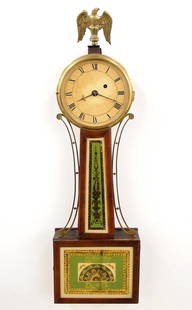 American Banjo Clock: A mid 19th century American banjo clock. 8-day time only movement with painted iron dial and Roman numerals. Mahogany case with a Brass Eagle finial over a molded Brass dial door, tapered throat