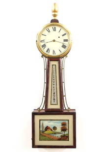 American Banjo Clock: A mid 19th century American banjo clock. 8-day time only movement with painted iron dial and Roman numerals. Mahogany case with a turned gilded finial over a molded Brass dial door, tapered hinged