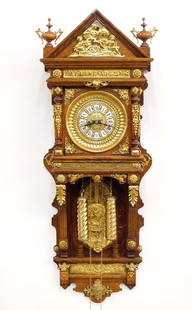Ansonia Antique Hanging Model Wall Clock: A 19th century Ansonia "Antique Hanging" Oak wall clock. 8-day weight driven time & strike movement with embossed Brass dial, porcelain hour markers, and Roman numerals with cast pendulum bob. Oak cas