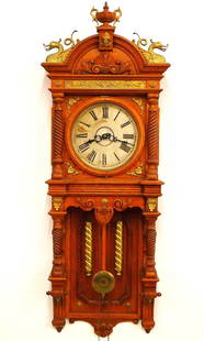 Waterbury Augusta Model Wall Clock: A late 19th century Waterbury "Augusta" model wall clock. 8-day weight driven time & strike movement with painted metal dial and Roman numerals. Oak case with cast Brass ornamentation features an arch