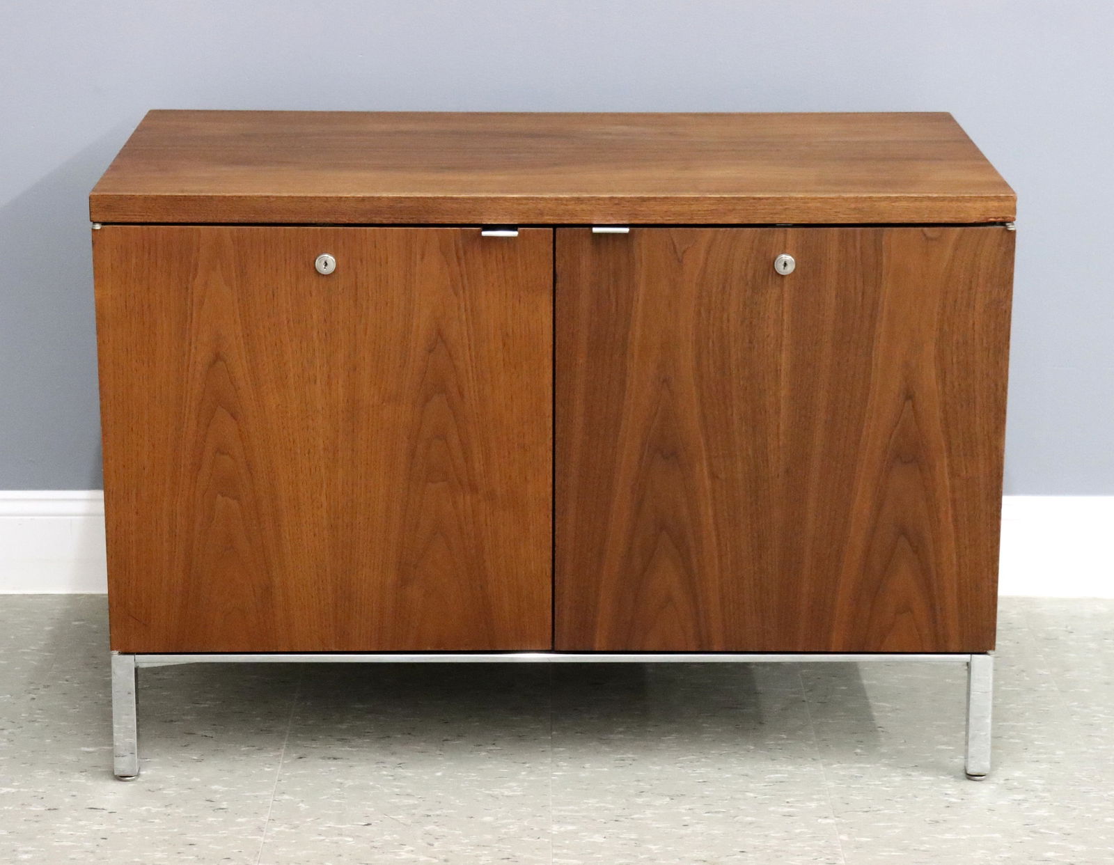 Mid Mod Cabinet: A Mid Mod Knoll style cabinet. Teak construction with two doors opening to a divided cabinet on a simple Chrome base. Original finish with minor wear, minor scratches and water spots to top. 38 x 20 x