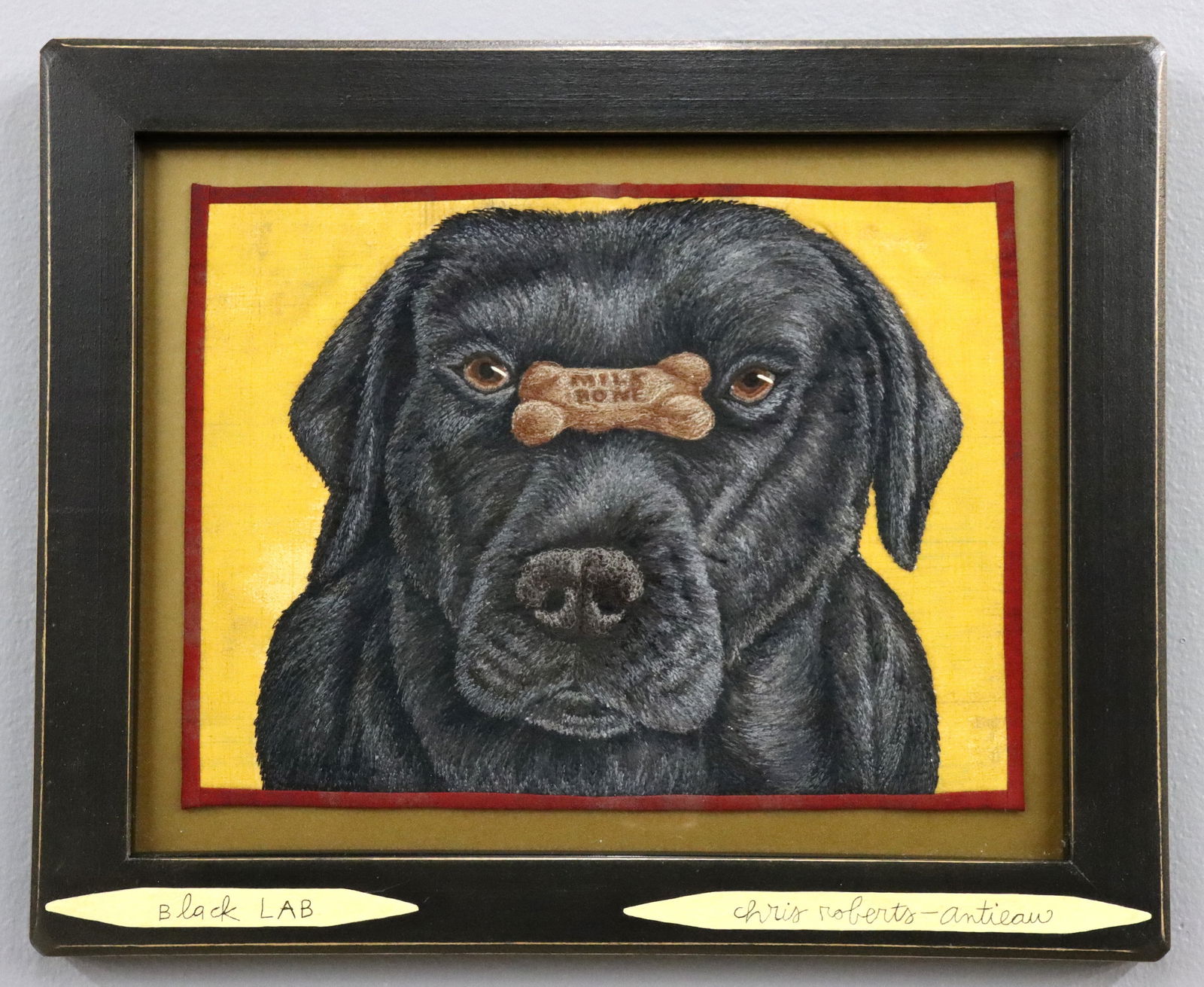 C. Roberts-Antieau Textile Black Lab: Chris Roberts-Antieau, American, b. 1950. An early 2000's fabric applique and embroidery composition titled "Black Lab" depicting a dog with a biscuit. Titled lower left and signed "Chris Roberts Anti