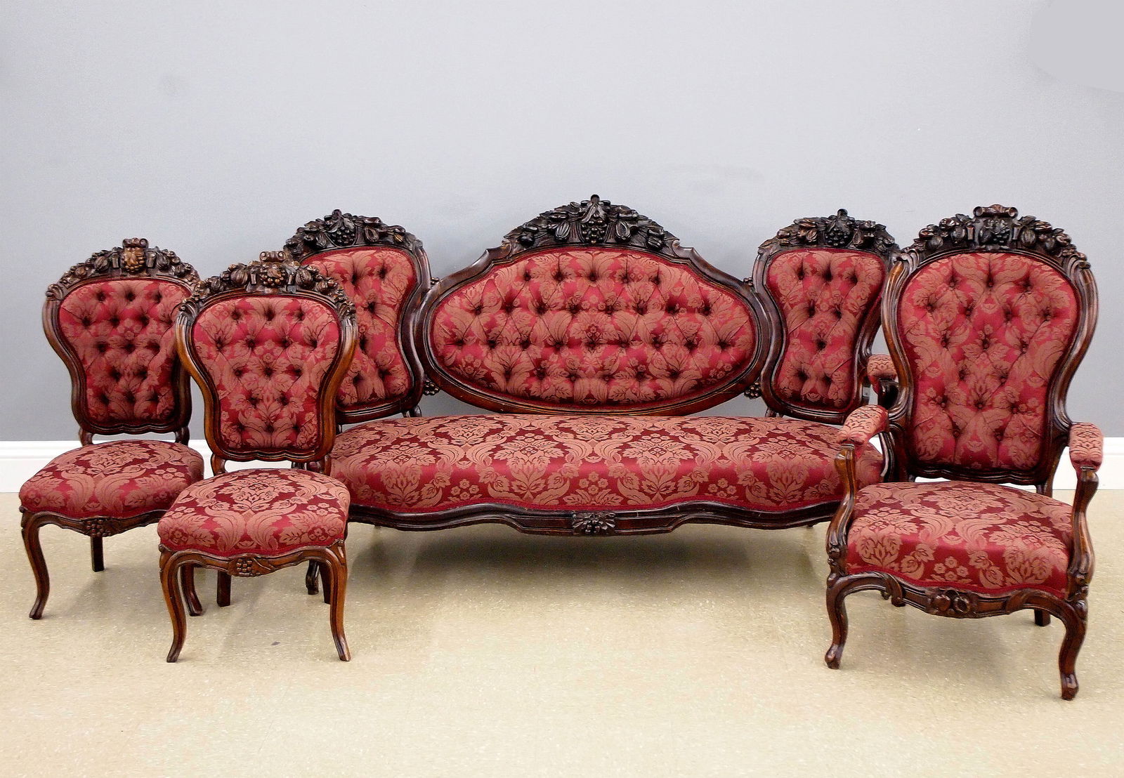 4 pc Victorian Parlor Set: A 19th century Victorian Rococo Revival Period four piece parlor set. Walnut construction with shaped backs and carved fruit and foliate crests, shaped skirts and cabriole legs. Includes a triple back