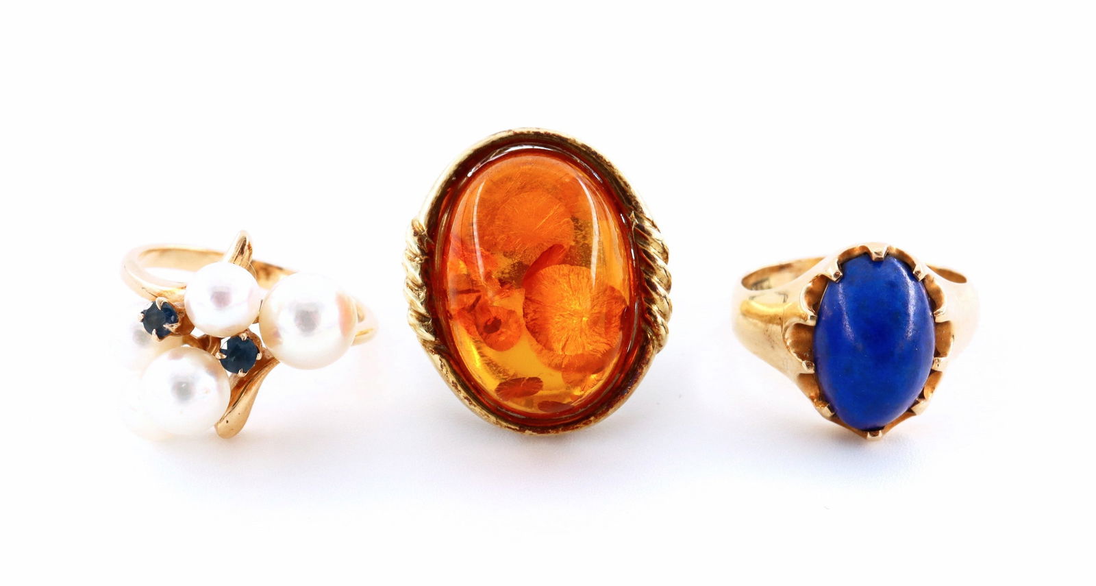 3 14k/15k Gold Rings: Three 14k/15k Gold rings. Includes a 14k Pearl and Blue Topaz cluster ring (size 5), a 15k ring with prong set Lapis Lazuli cabochon (size 4 1/2), and a 14k ring with oval Amber (size 4 1/2). Marked "