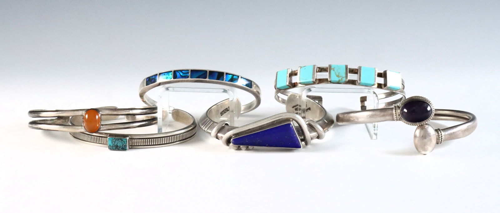 6 American Southwest Sterling Bracelets: Six American Southwest style Sterling Silver bracelets. Includes a cuff with Lapis Lazuli by Navajo artist Orville Tsinnie, a cuff with Turquoise by Navajo artist Kee Nataani and four others with vari