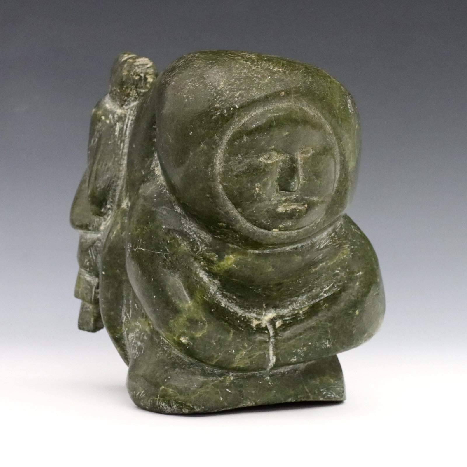 Intuit Serpentine Mother & Child: A 20th century Inuit carved Serpentine figure of a mother with a child at her back. Minor surface wear. 5 1/2" high. ESTIMATE $200-400