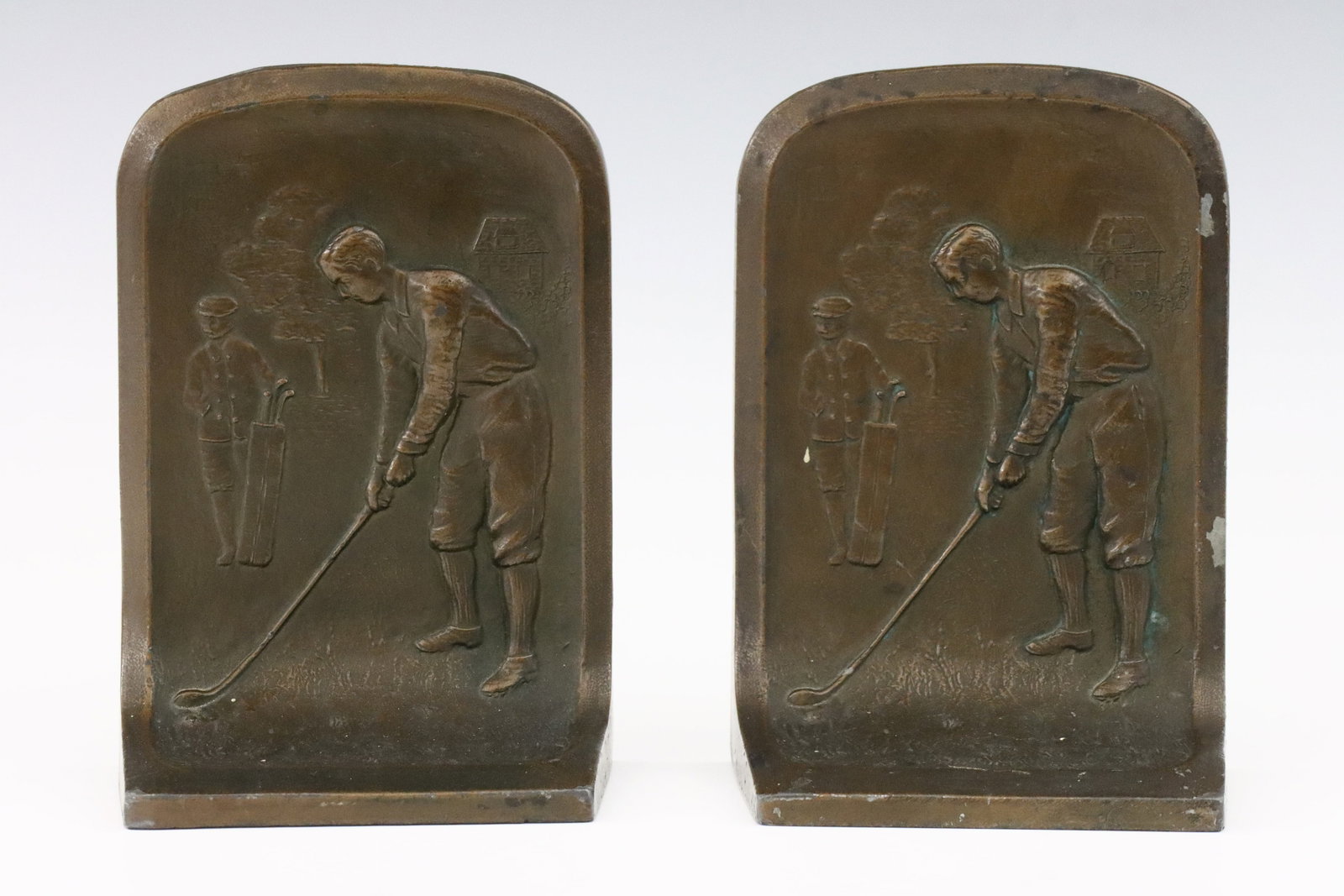 Pr Golfing Bookends: A pair of early 20th century cast Lead bookends with golf design. Each depict a golfer and caddy with bronzed patina. Cast "105" at backs. Some wear to patina. Each 5 1/2" high. ESTIMATE $100-150