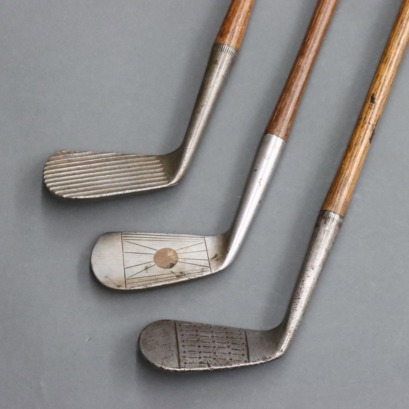 3 American Iron Golf Clubs: Three early 20th century American scored face iron golf clubs. Includes a Spalding "Dedstop" Series "F. Dickson Special" mashie with deeply scored face c. 1922, a Spalding "Medal" Series mashie c. 191