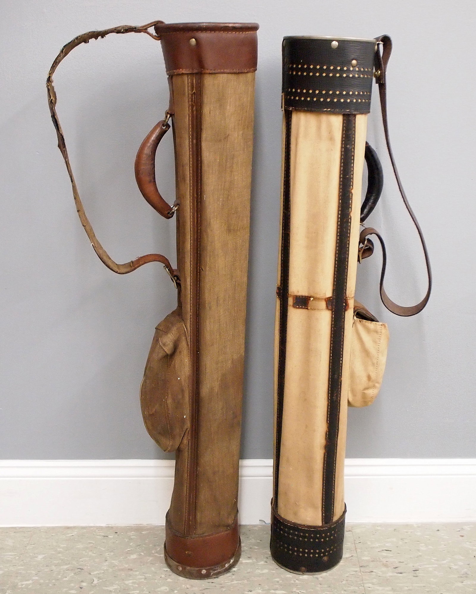 2 Canvas Golf Bags: Two early 20th century golf bags. Canvas stovepipe style bags with leather trim and metal bottoms. One with embossed patent "PAT 6-12-17" at bottom. Wear, some damage and minor staining, one with repl