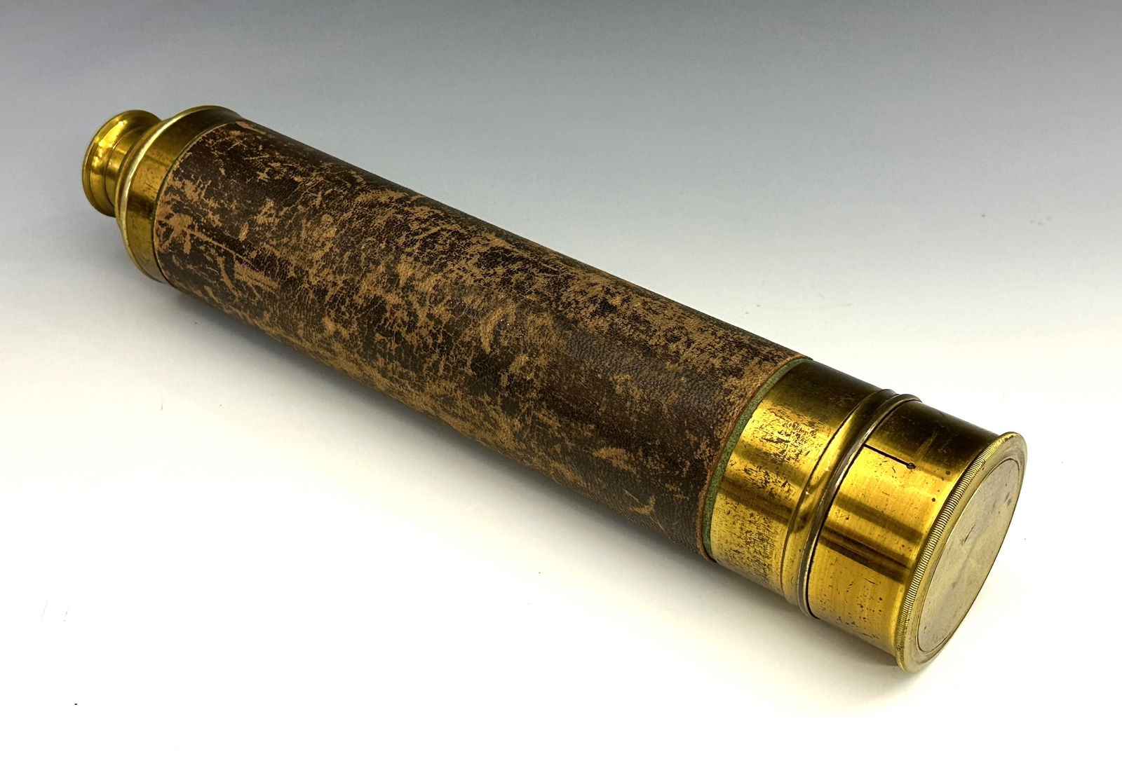 Brass Four-Draw Telescope: A 19th century Brass four-draw telescope. Leather covered barrel with 2" objective lens, lift-off and sliding Brass lens covers. Some wear to patina, pitting and surface scratches, leather with wear.