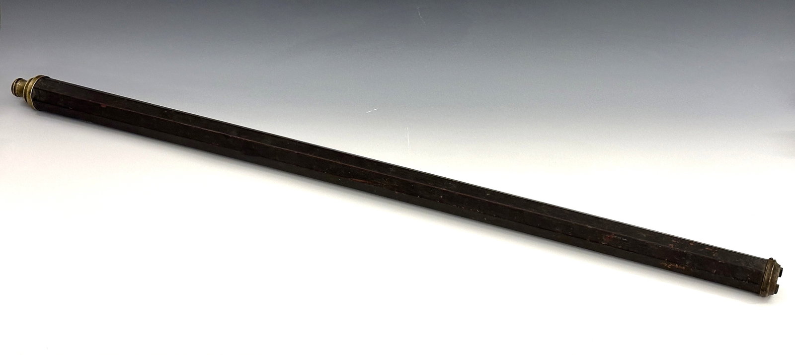 Early Brass Single-Draw Telescope: An 18th century Brass single-draw long telescope. Octagonal tapered hardwood barrel with 1" objective lens, removable draw and sliding Brass lens cover. Some wear to patina, old dark finish with minor