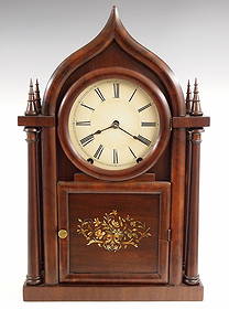 E. C. Brewster Gothic Shelf Clock: A 19th century E. C. Brewster Gothic shelf clock. 8-day time and strike movement with painted metal dial and Roman numerals. Mahogany case with "Onion" top above a single door with circular dial glass