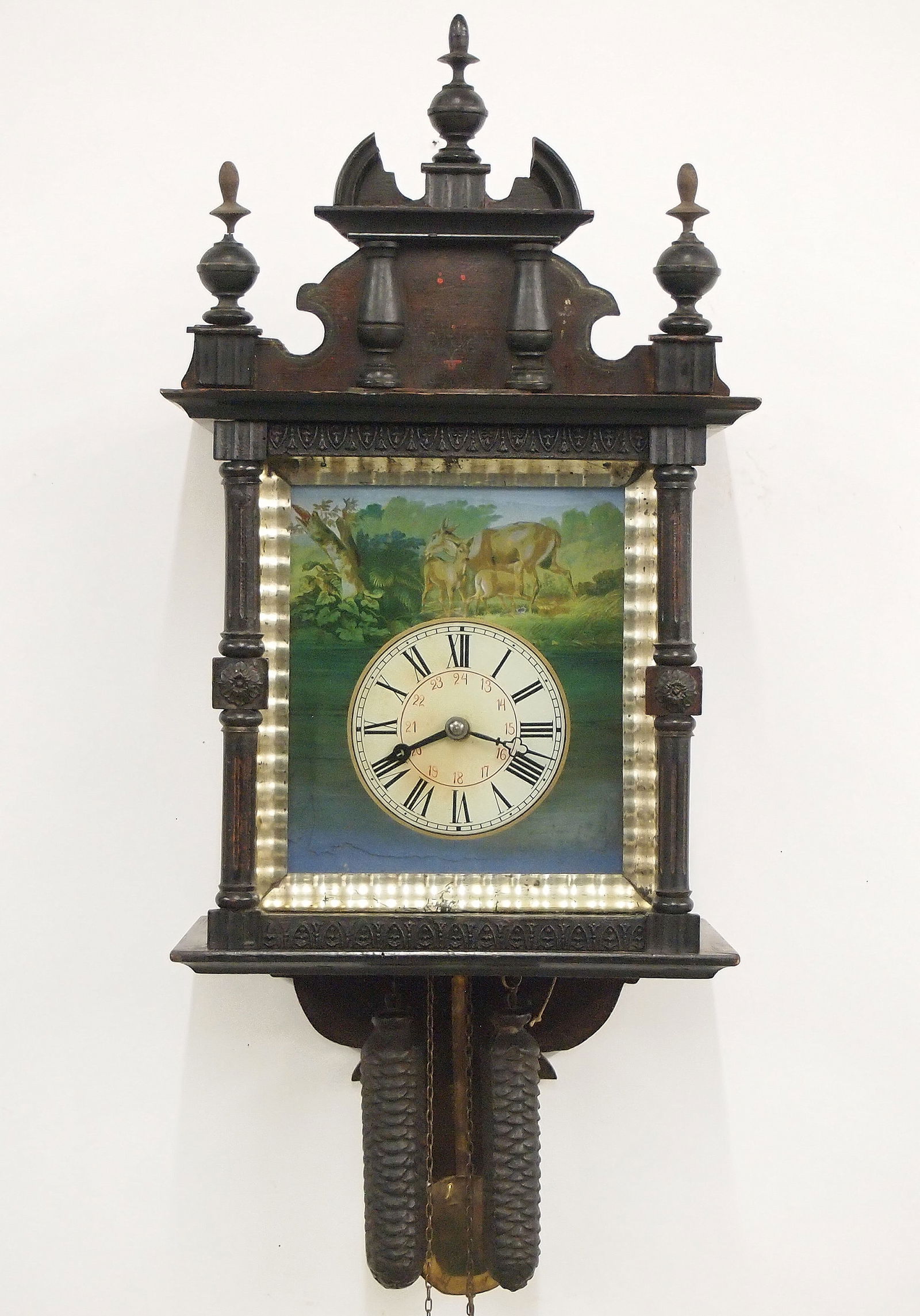 Black Forest Wag On The Wall: A late 19th century Black Forest wag on the wall clock. 30-hr with driven time and strike wooden "Birdcage" movement with reverse painted glass dial with Roman/Arabic numerals below a forest scene wit