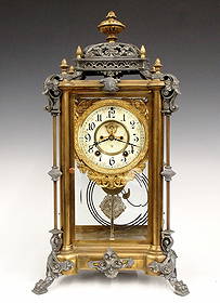 Ansonia Excelsior Model Crystal Regulator: A turn of the century Ansonia Excelsior model crystal regulator. 8-day time and strike movement with visible escapement and two part porcelain dial with Arabic numerals, fancy cast bezel. Brass and sp