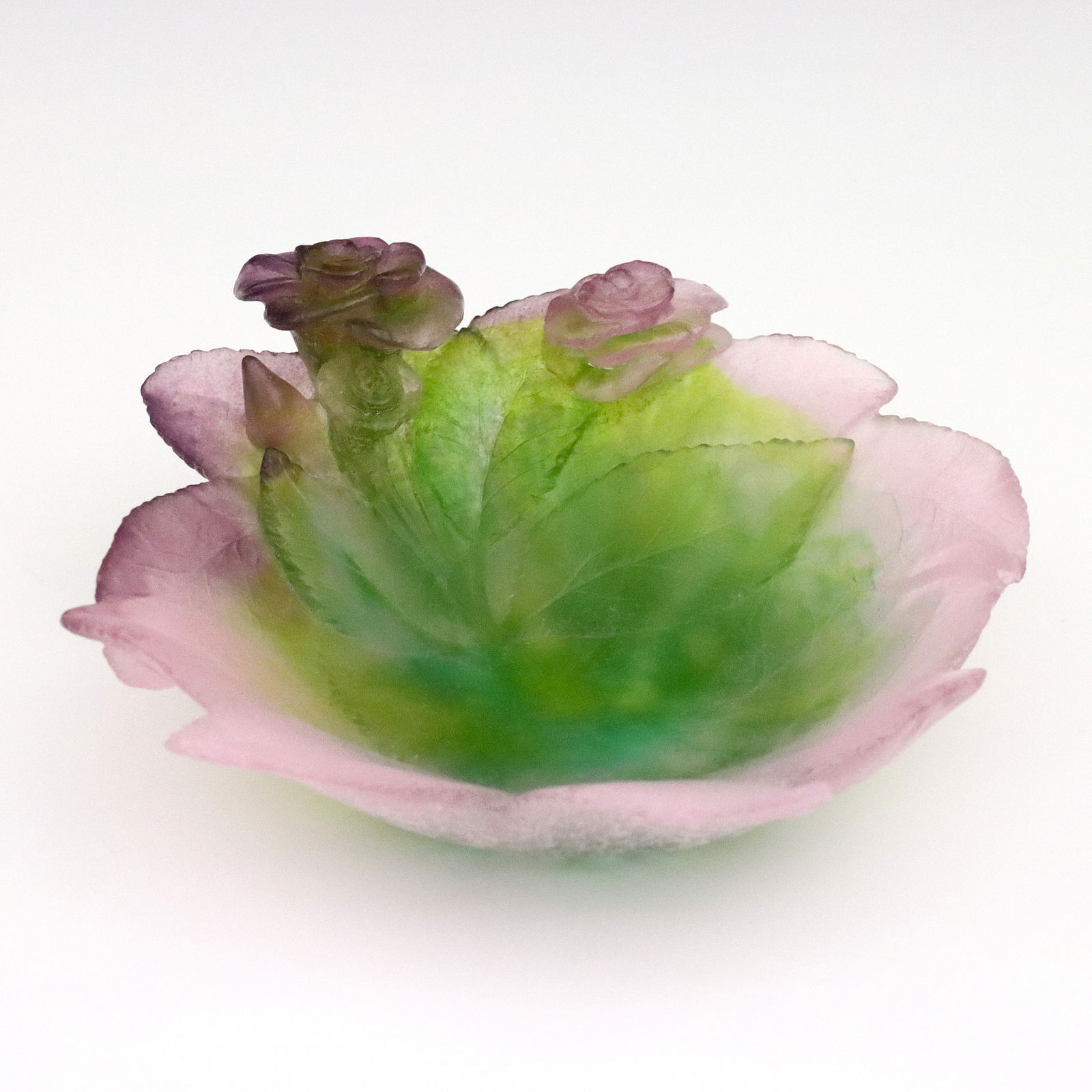 Daum Pate de Verre Rose Bowl: A late 20th century Daum Pate de Verre Rose bowl. Molded glass bowl with Rose and leaf design in shades of Pink, Lavender and Green. Signed "Daum France" at underside. Small chip to one leaf point. 7