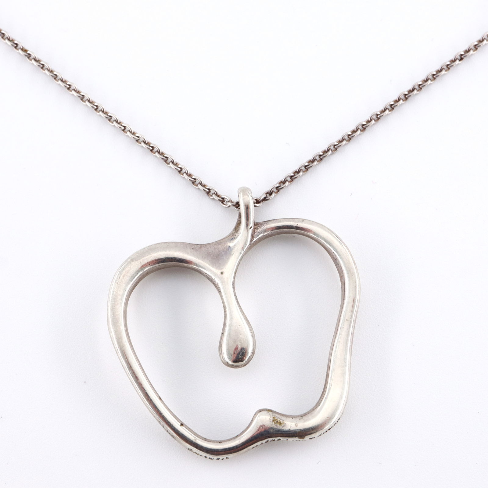 Peretti for Tiffany Sterling Apple Necklace: A contemporary Elsa Peretti for Tiffany & Co. Sterling Silver apple necklace. Features a stylized apple pendant on a long 12k White Gold Filled chain necklace. Marked "Tiffany & Co. / Peretti" and "St