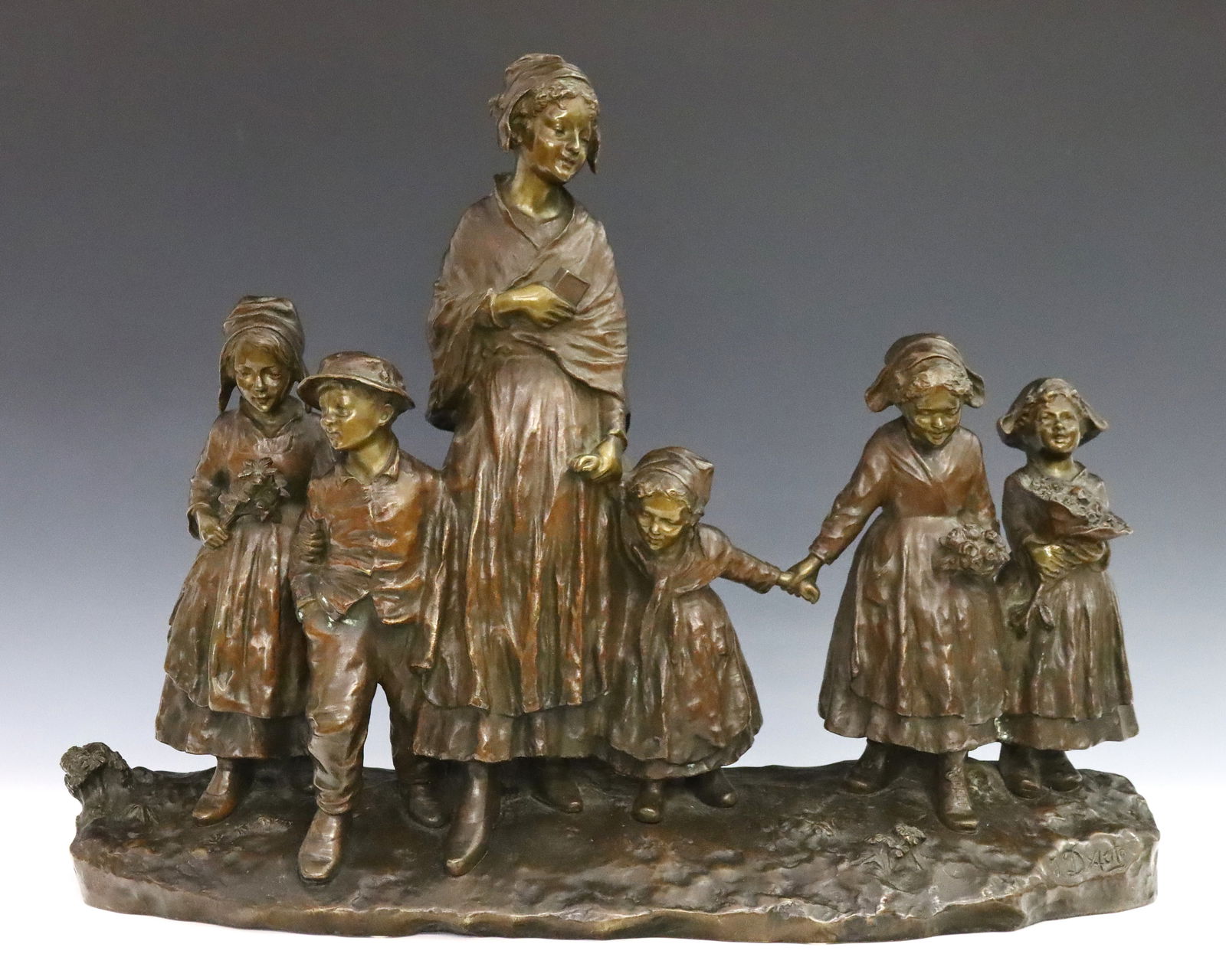 J. D'Aste Bronze Figural Grouping: Joseph D'Aste, Italian/French, 1881-1945. An early 20th century Bronze figural grouping, titled "Fete Au Village". Depicts several children carrying flowers alongside a young woman holding a book