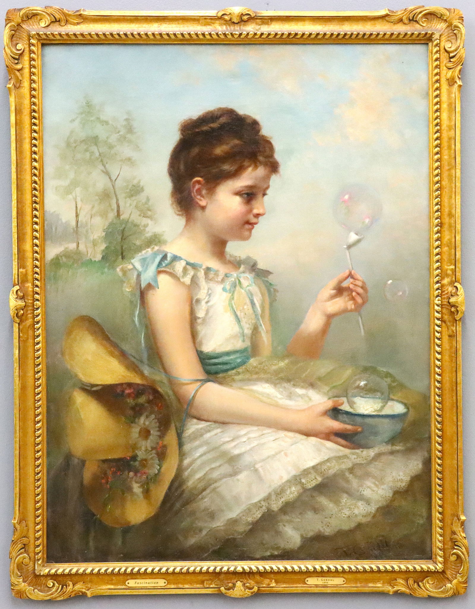 Portrait of a Girl Blowing Bubbles: A turn of the century oil on canvas portrait of a girl blowing bubbles. Depicted half length and seated, wearing a White dress and a straw hat adorned with flowers, holding a bubble wand with a landsc