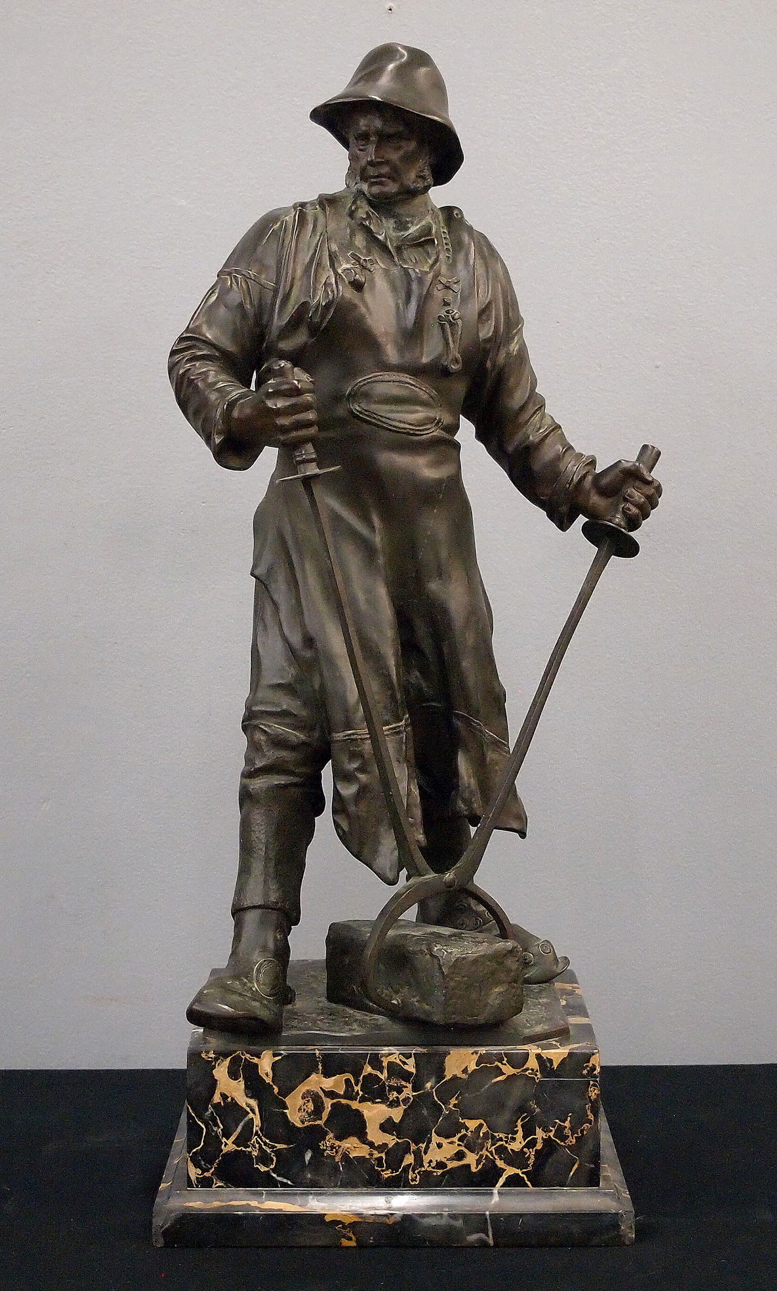 F. J. Reusch Bronze Figure: Friedrich Johann Reusch, German, 1843-1906. A late 19th century Bronze figure, entitled "Siegerland Steelworker", 1893. Depicts a German steelworker with tongs and a steel bar. Presented on a Gold/Bla