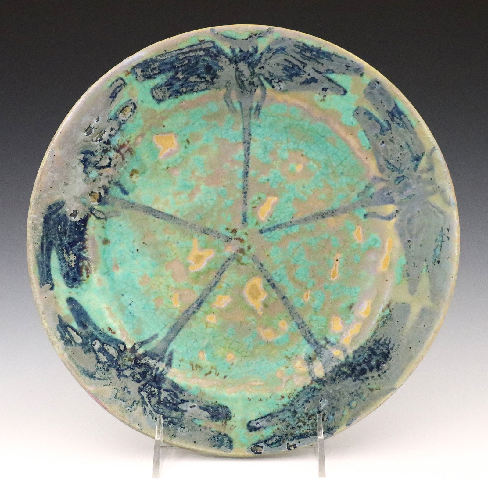 Pewabic Pottery Dragonfly Plate: An early 20th century Pewabic Pottery plate. Circular form decorated with Blue Arts & Crafts style Dragonflies with Iridescent glaze in shades of Green and Blue. Unmarked. Wear, crazing, painted touch