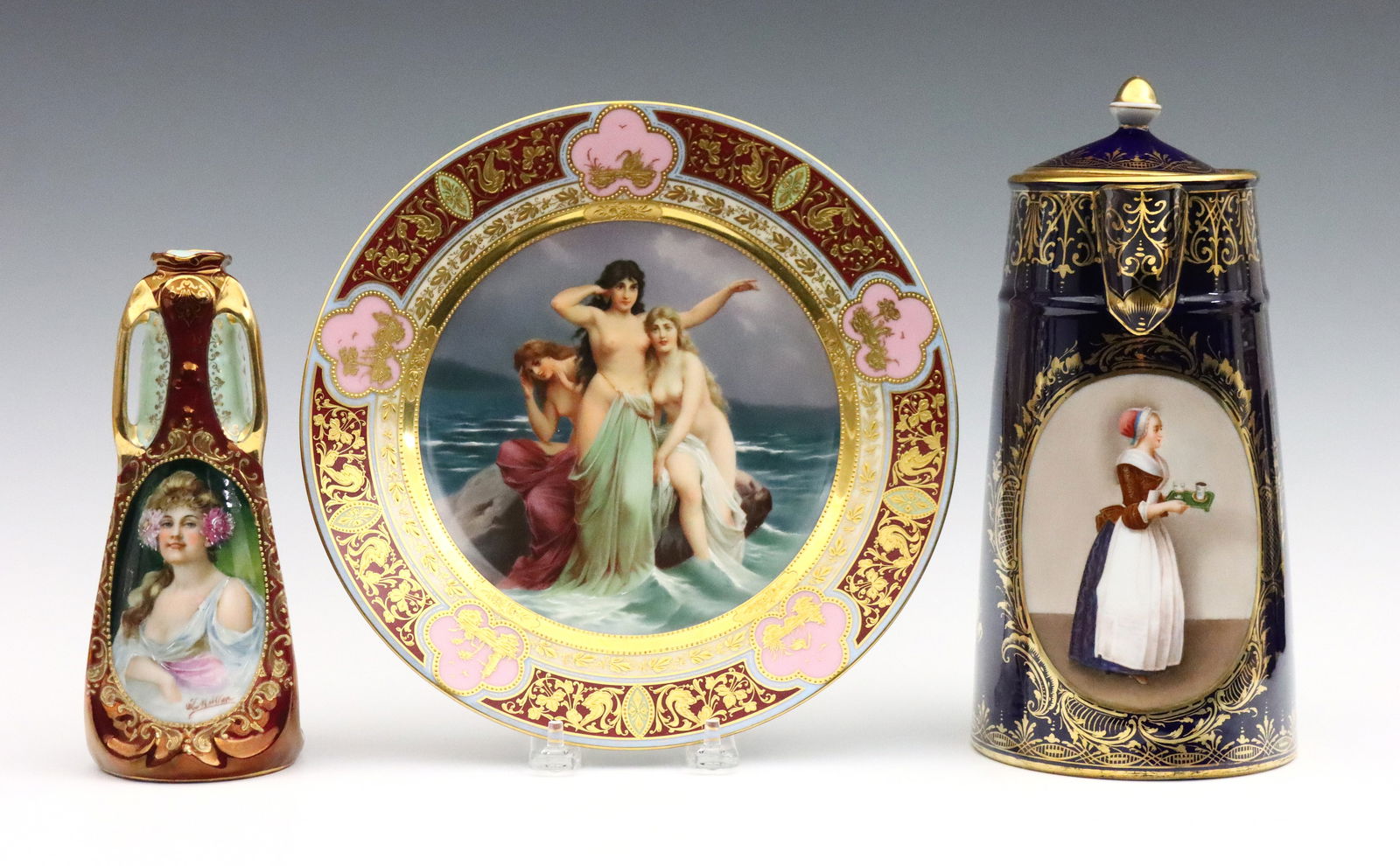 3 pc Royal Vienna Style Porcelain: Three pieces of turn of the century Royal Vienna style porcelain. Hand-painted scenes with Gilded detail, includes a "Sirens" cabinet plate, a chocolate pot with a portrait of a woman serving drinks,