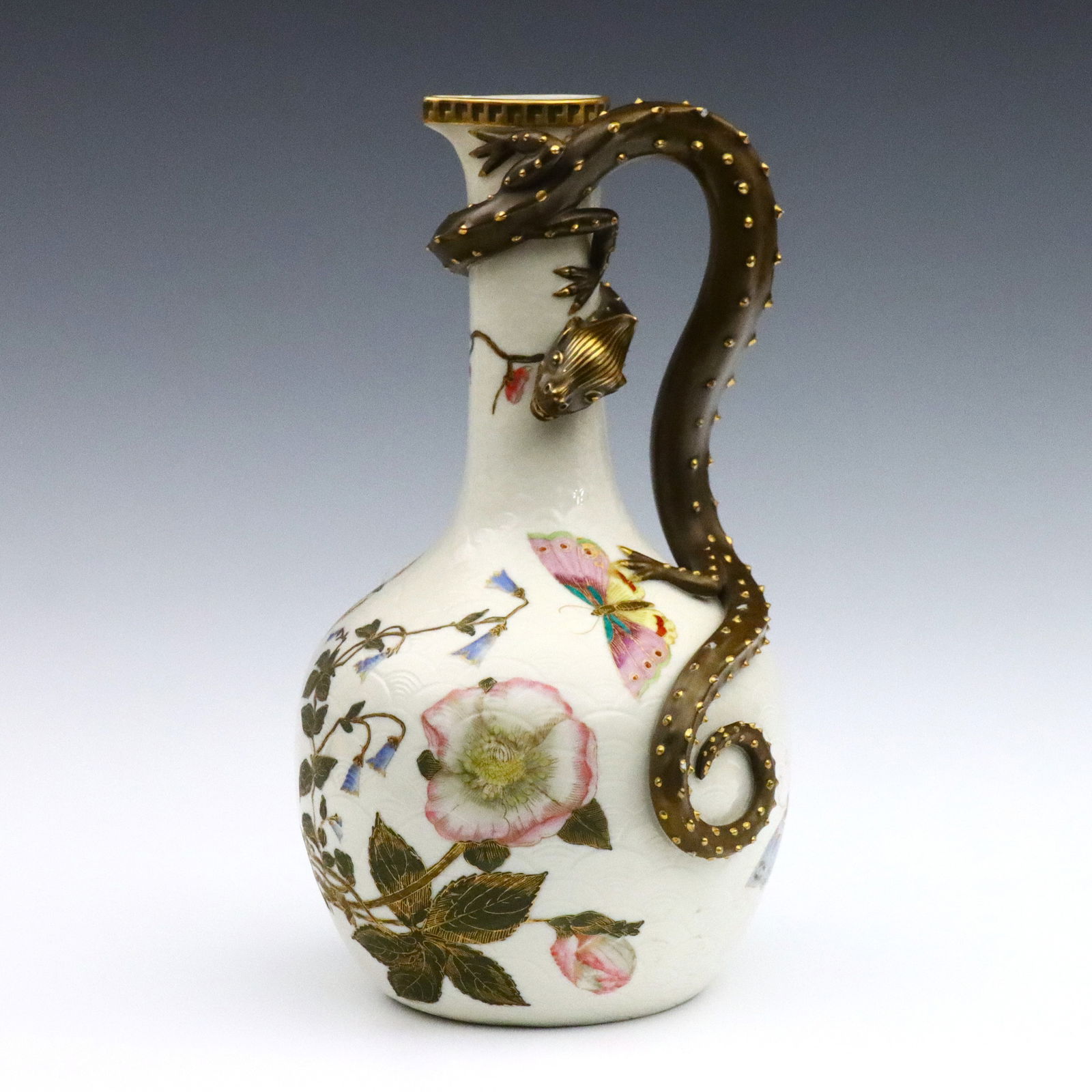 Royal Worcester Porcelain Dragon Ewer: A late 19th century Royal Worcester porcelain ewer retailed by J.E. Caldwell & Co. Bottle form ewer with applied Dragon handle and enameled Chinoiserie decoration depicting butterflies and flowers on