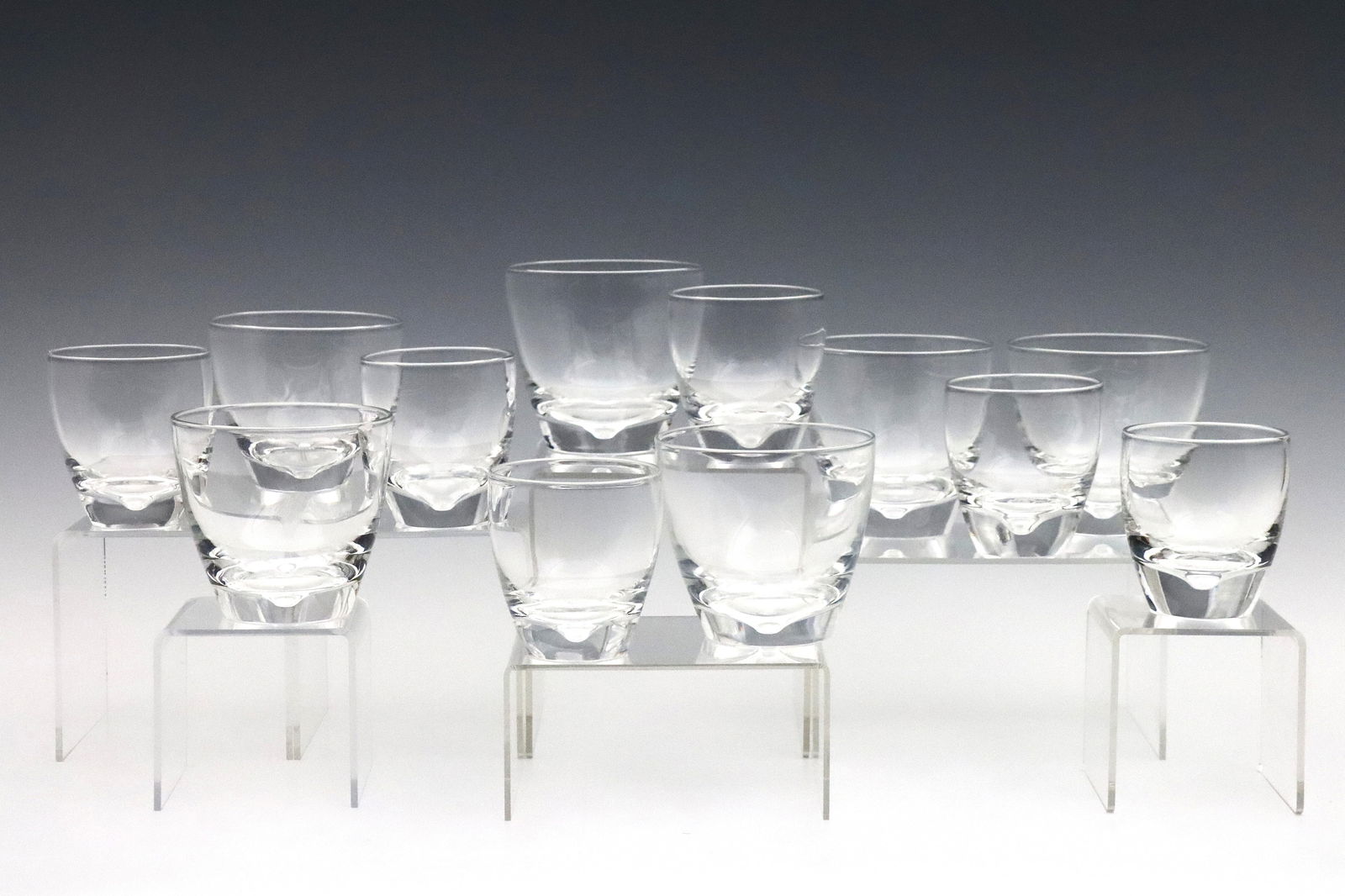12 Steuben Crystal Glasses: A set of twelve mid 20th century Steuben Crystal glasses designed by George Thompson. Includes six shape #7937 cocktail glasses, and six shape #7933 old fashion glasses with dimple design. En suite wi