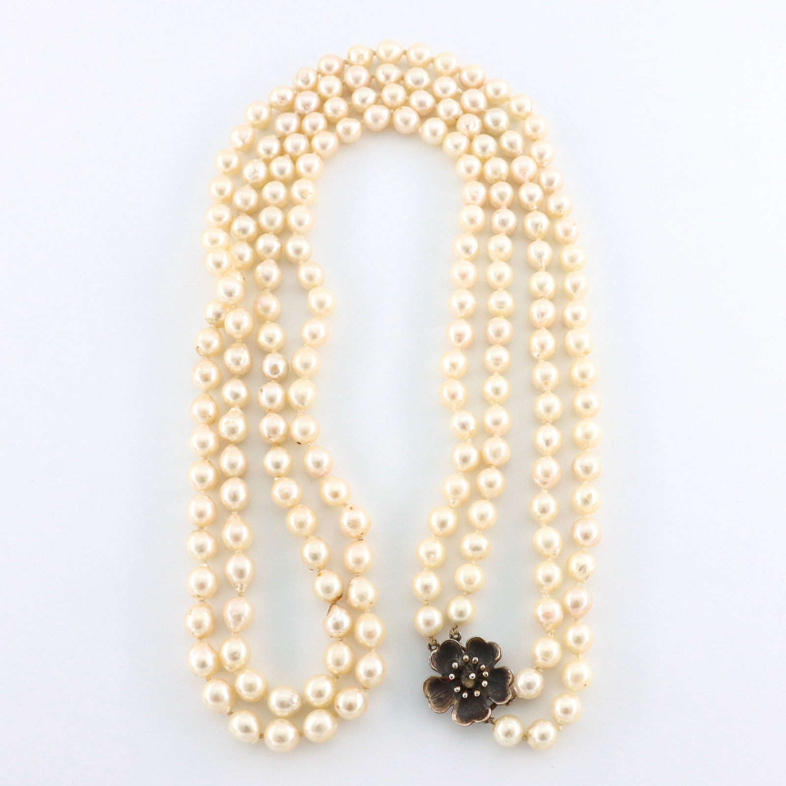 Ming's Pearl Necklace: A Ming's multi-strand Pearl necklace with Sterling Silver clasp. Features two strands of round Pearls, averaging 7.5 to 8.5 mm, with a floriform Gilded Silver clasp. Marked "Ming's" and "SS",