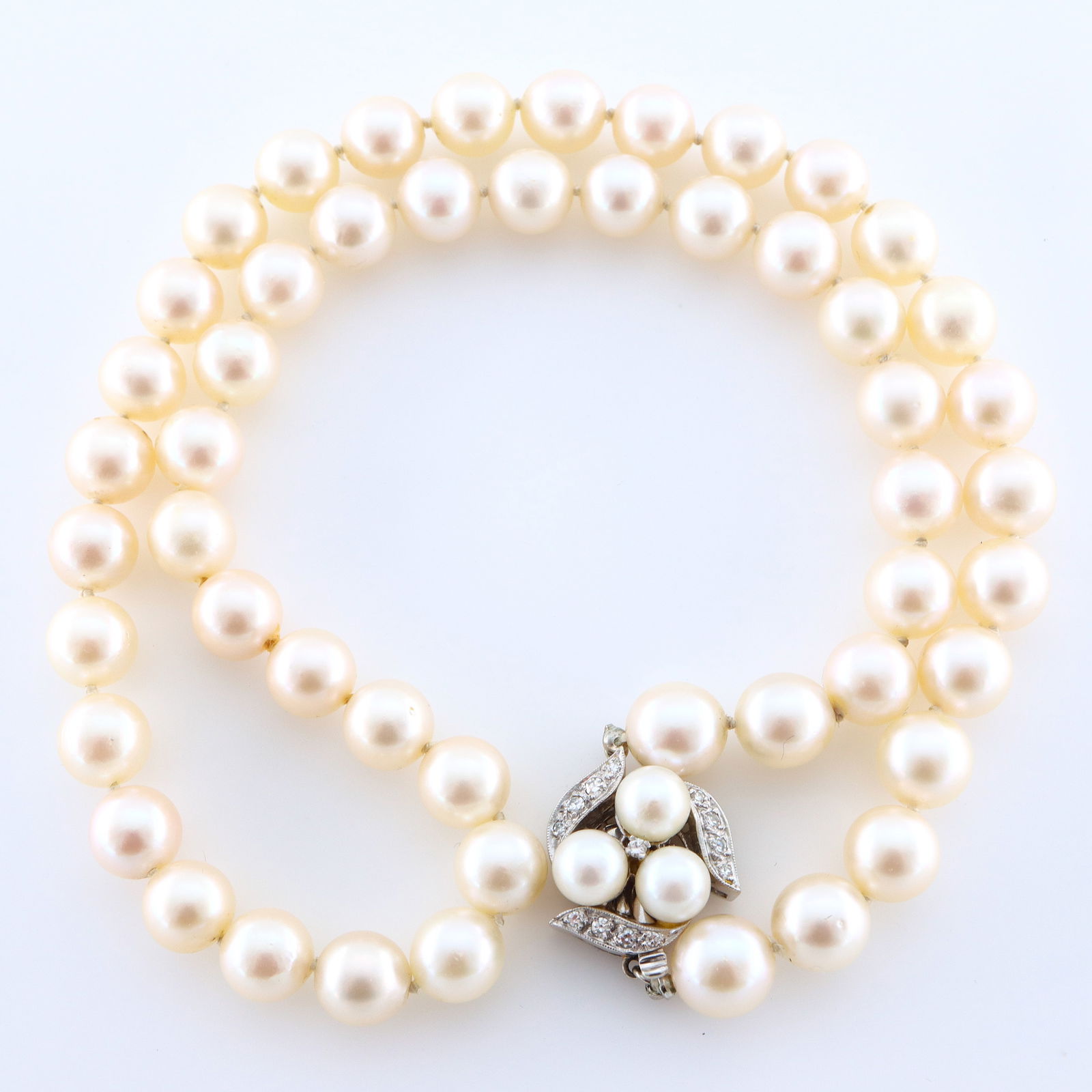 14k Gold, Pearl & Diamond Necklace: A Pearl necklace with 14k Gold clasp and Diamonds. Features a single strand of fifty-one hand-knotted round Pearls, averaging 8 mm, with a 14k White Gold clasp having a filigree design with Diamonds a